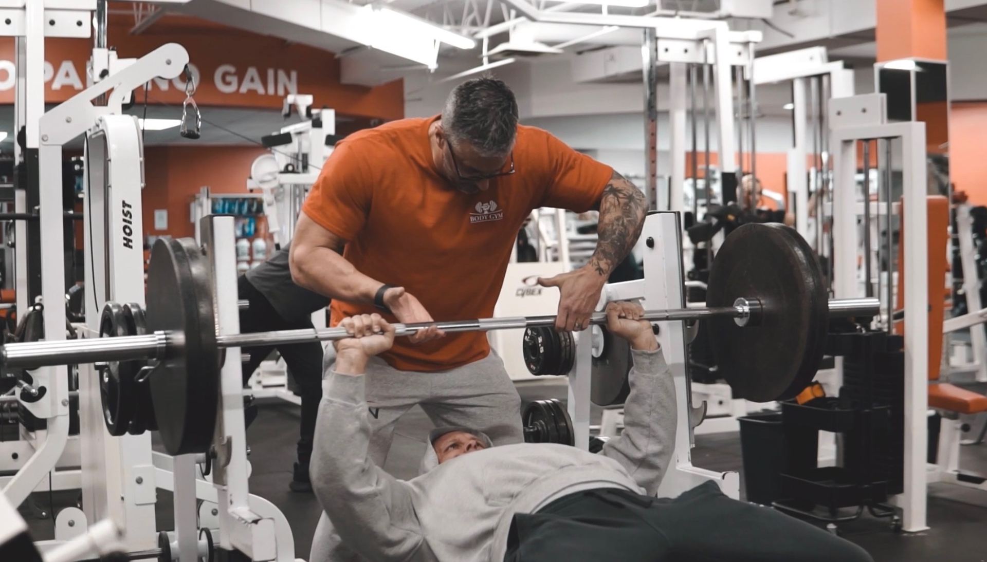Entraîneur en action — spotting musculation Body Gym